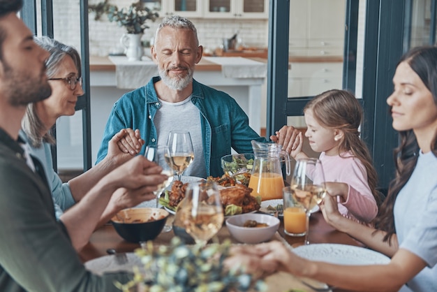 Premium Photo | Happy multigeneration family holding hands and praying ...