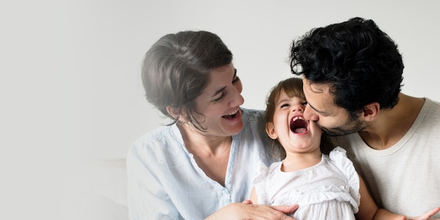 Happy parents laughing together with daughter Free Photo