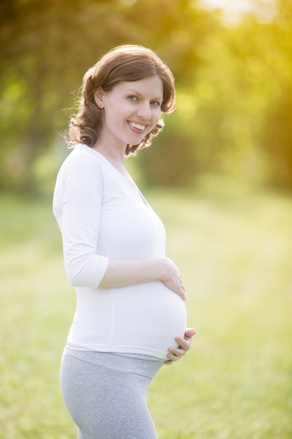 Happy pregnant woman on late pregnancy period walking in park Photo ...