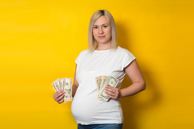 黄色の壁に妊娠中の女性のための利点を持つ幸せな妊娠中の女性 妊婦のメリット プレミアム写真
