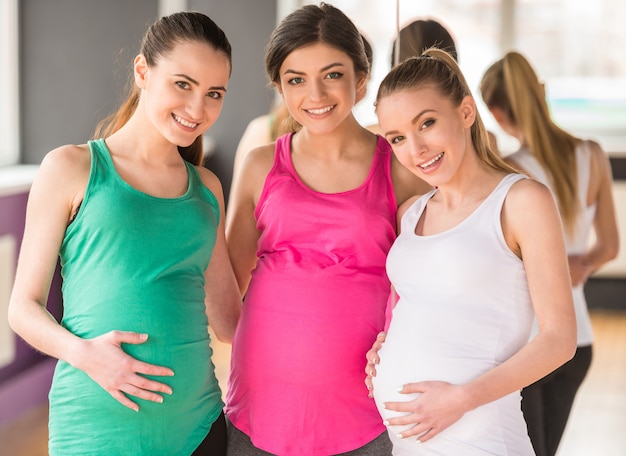 Happy pregnant women are looking at the camera. Premium Photo