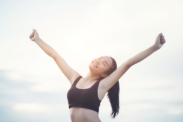 Happy smiling athletic woman with arms outstretched Free Photo