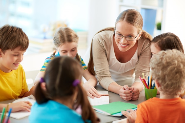 Happy teacher listening to her students Free Photo