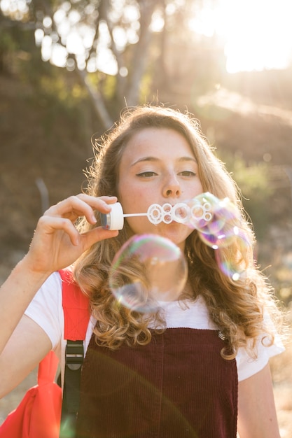 Free Photo | Happy teenager blowing bubbles in park