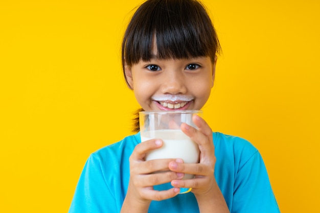 Premium Photo Happy Thai Kid Holding Glass Of Milk Isolated Young Asian Girl Drinking Milk For Strong Health On Yellow