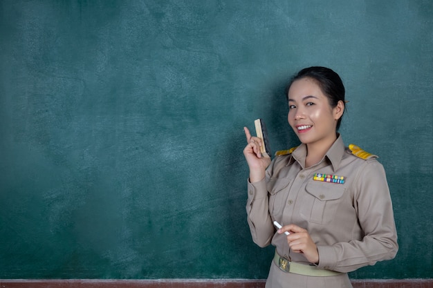 Happy Thai Teacher In Official Outfit Posing In Front Of Blackboard