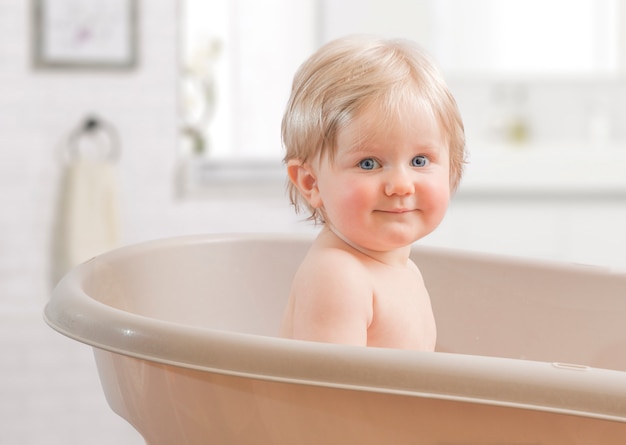 Premium Photo | A happy toddler bathing in bathtub.