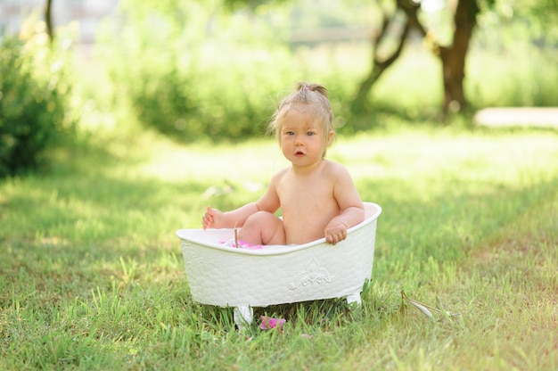 Premium Photo | Happy toddler girl takes a milk bath with petals ...