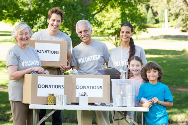 Premium Photo | Happy volunteer family separating donations stuffs