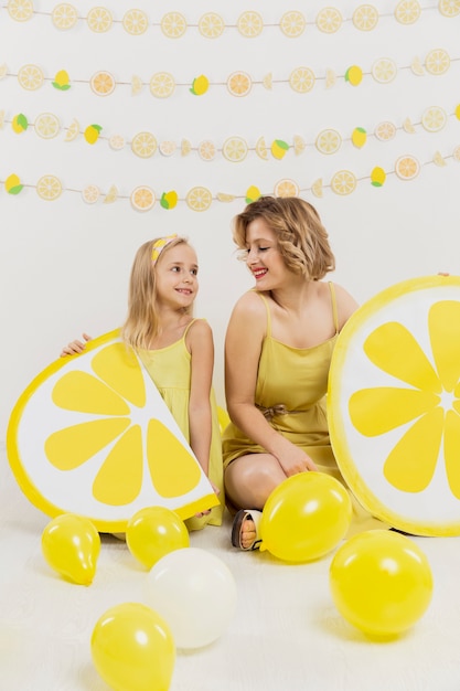 幸せな女とレモンの飾りと風船でポーズの女の子 無料の写真