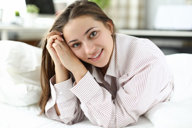 Premium Photo | Happy woman in a mans shirt lies on the bed