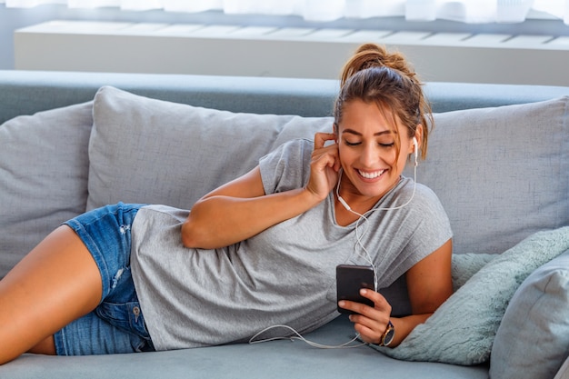 Happy woman with earphones listening to music Premium Photo