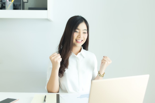 Premium Photo | Happy young asian business woman finished her work at  workplace.
