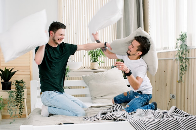 happy-young-gay-couple-is-having-fun-bed-enjoying-company-each-other-pillow-battle_161094-1279.jpg