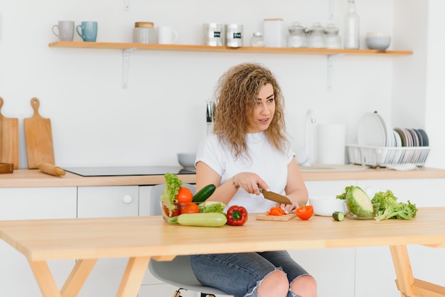 Premium Photo | Happy Young Housewife Mixing Vegetable Salad