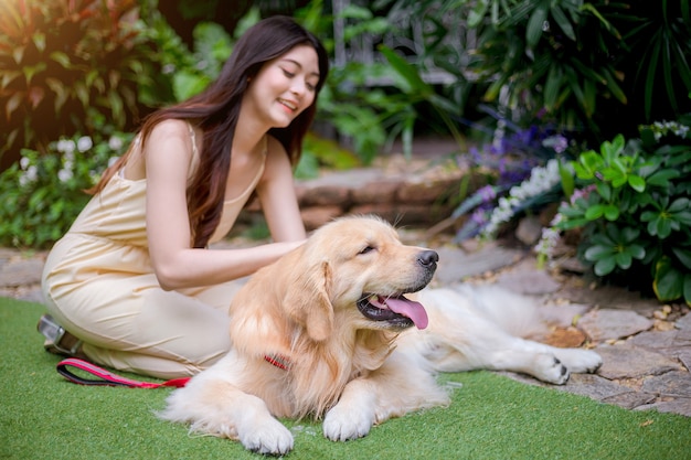 Premium Photo | Happy young woman holding dog golden retriever.