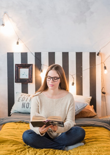 Free Photo Happy Young Woman Reading Book In The Bedroom