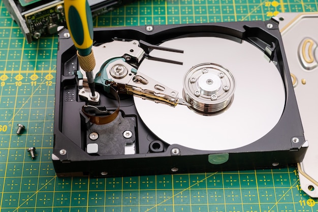 Premium Photo | Hard disk drive disassembling process with screwdriver ...