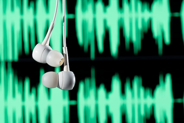 Premium Photo | Headphone hanging with sound waves on blurred background