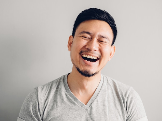 Headshot photo of Asian man with laugh face. on grey background. Premium Photo