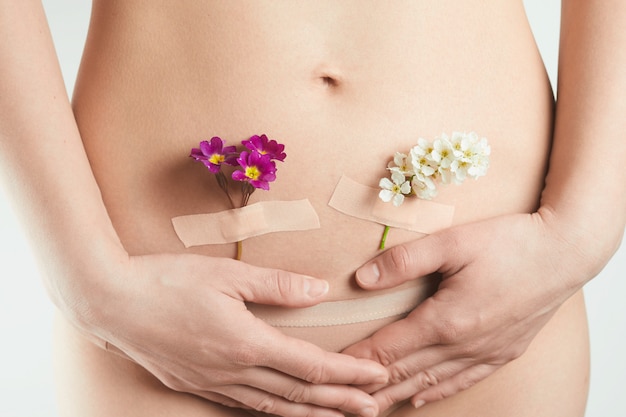 Здоровье женской репродуктивной системы. красивая женщина с цветами на ее  коже. концепция беременности и гинекологии | Премиум Фото