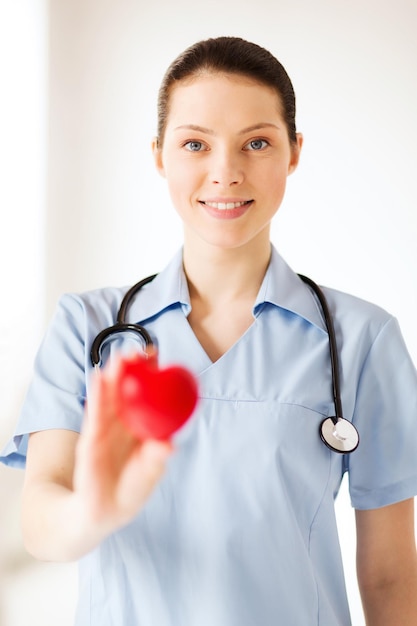  Healthcare and medical concept - female doctor with heart Premium Photo