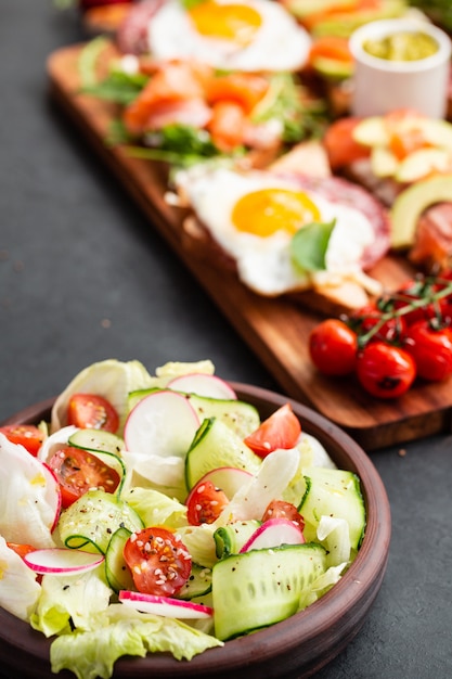 Healthy Classical Vegetable Fresh Salad Of Lettuce Tomato Cucumber Onion And Sesame With Olive Oil Dressing On Black Plate And Gray Premium Photo