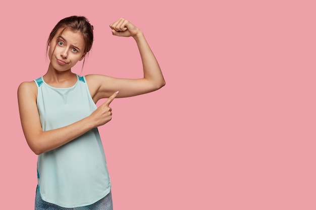 Healthy lifestyle and sport concept. dissatisfied european woman points at arm muscle Free Photo, ako pribrať, pribrať