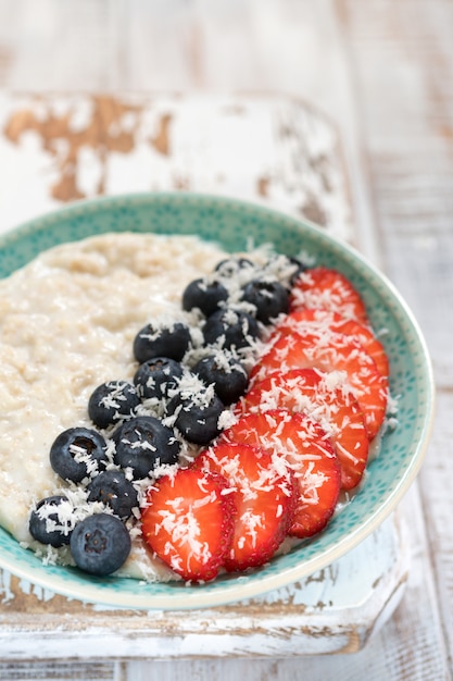 Premium Photo | Healthy oatmeal with shredded coconut, blueberries and ...