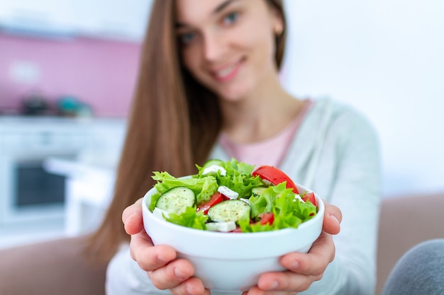 Healthy vegan woman holding a bowl of fresh vegetable salad. balanced organic diet and clean eating Premium Photo