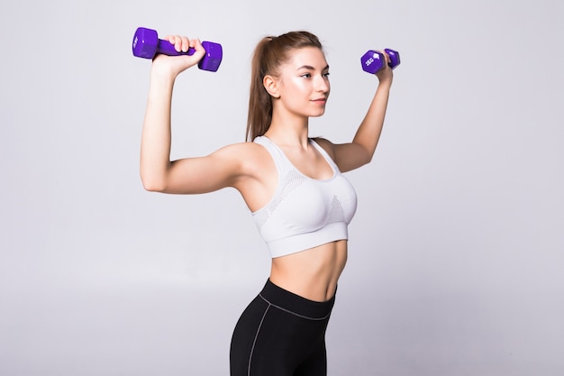 Healthy woman with dumbbells working out isolated on white wall. fitness gym concept Free Photo
