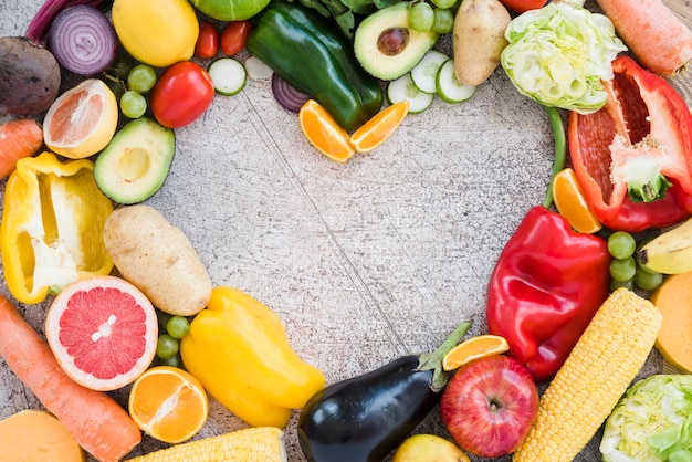 Heart shape made with colorful vegetables on textured backdrop Free Photo