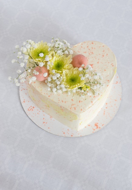 Heart Shaped Cake Decorated With Fresh Flowers On A White