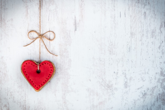 Premium Photo | Heart shaped cookie tied with hemp bow over white wood ...