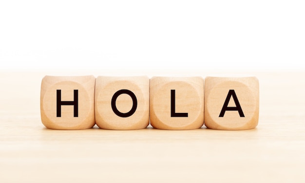 Hello word in spanish language in wooden blocks on table. Premium Photo