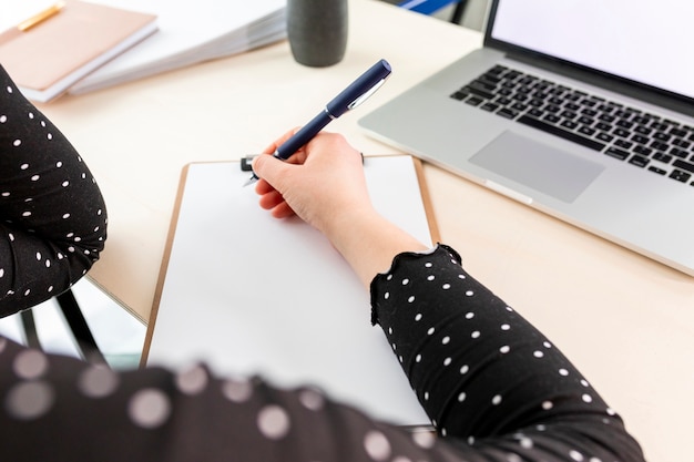 High angle business woman taking notes on clipboard | Free Photo