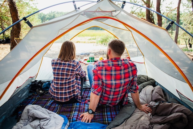 High angle couple enjoying nature view from tent Free Photo