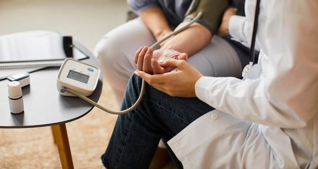 High angle of covid recovery center female doctor checking elder patient's blood pressure Free Photo