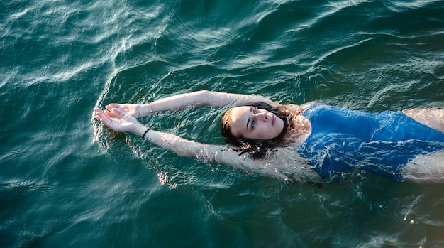 水に浮かぶ女性スイマーのハイアングル 無料の写真