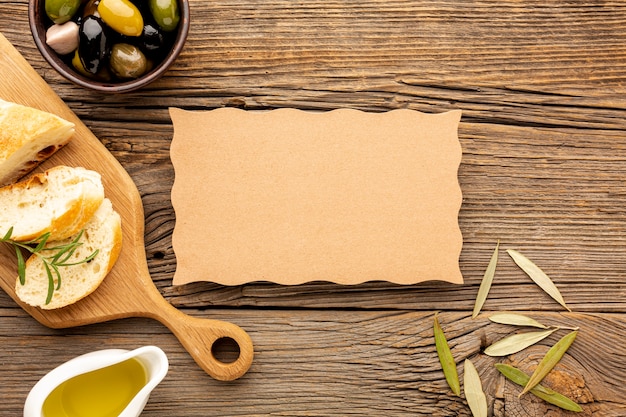 High angle olives mix bread and oil saucer with cardboard mock-up Free Photo