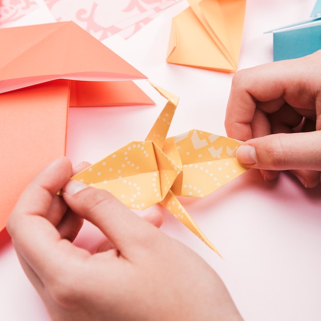 Free Photo | High angle view of artist hand holding origami paper bird