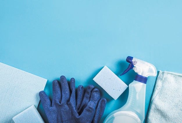 High angle view of spray bottle, gloves and sponge on blue background Free Photo