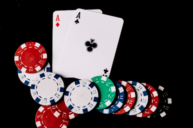 https://image.freepik.com/free-photo/high-angle-view-poker-chips-two-aces-playing-cards-black-backdrop_23-2147937946.jpg