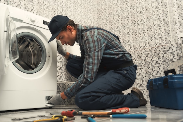  High quality workmanship plumber repairing washing machine Premium Photo