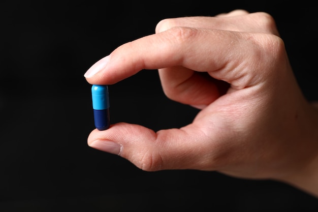 Free Photo | Holding a blue medical pill in the hand.