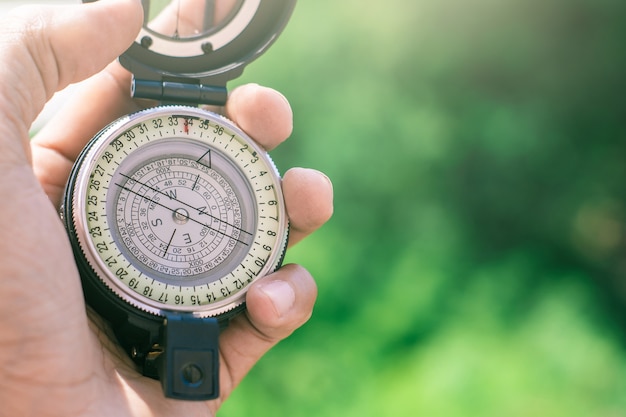 Holding compass on blurred background. using wallpaper or background travel or navigator image. Premium Photo
