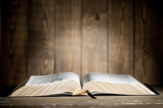 Premium Photo | Holy bible book on a wooden background