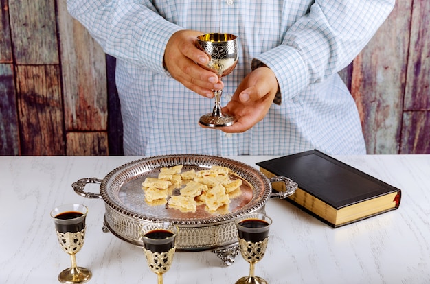 Premium Photo | Holy communion cup of glass with red wine, bread bible