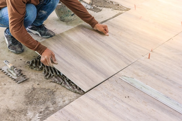 Home improvement, renovation - construction worker tiler is tiling Premium Photo