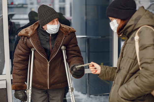 冬の街でホームレス 食べ物を求める男 無料の写真